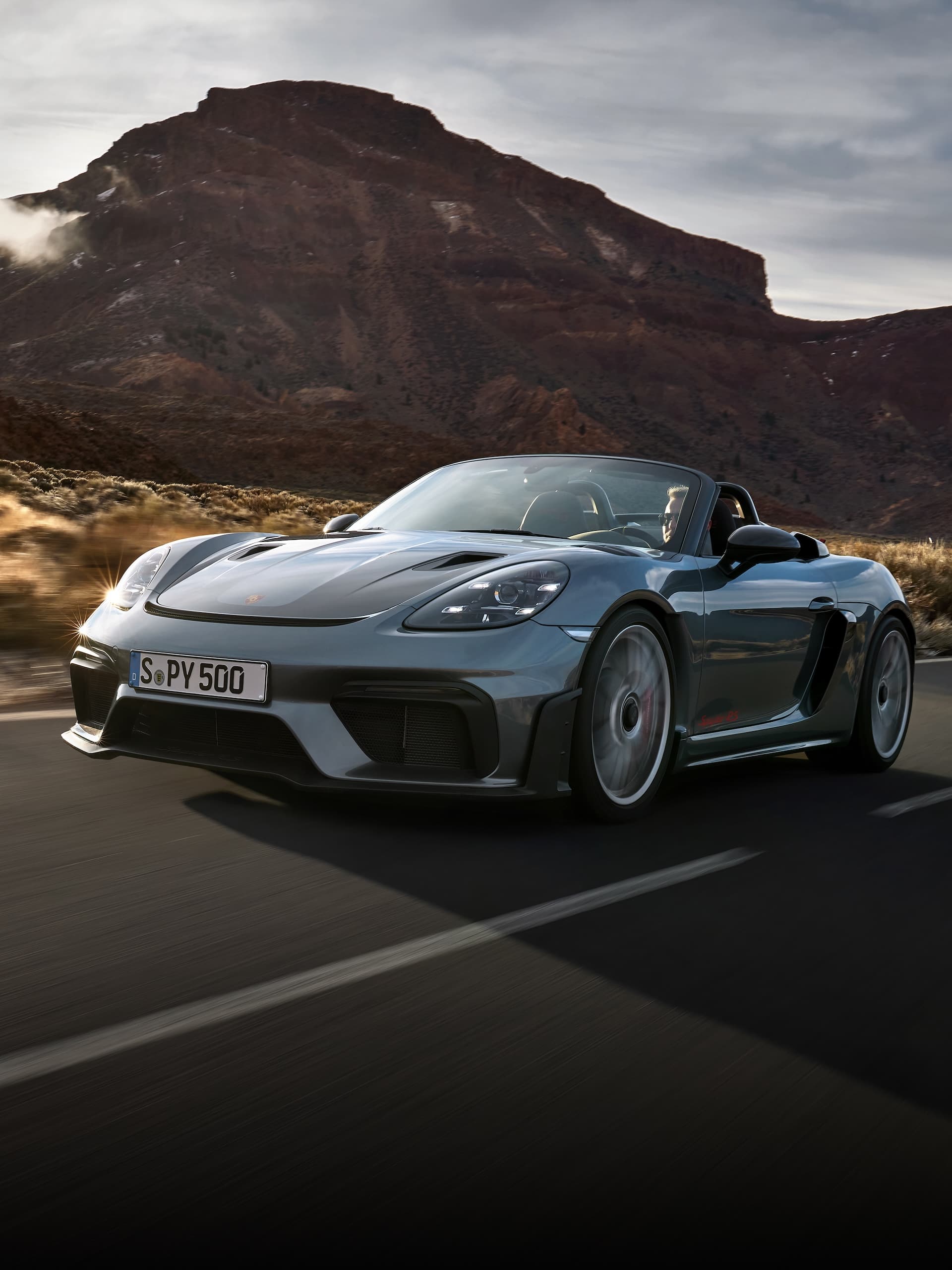 Porsche 718 Spyder RS fährt auf der Strasse zwischen Felsformationen.